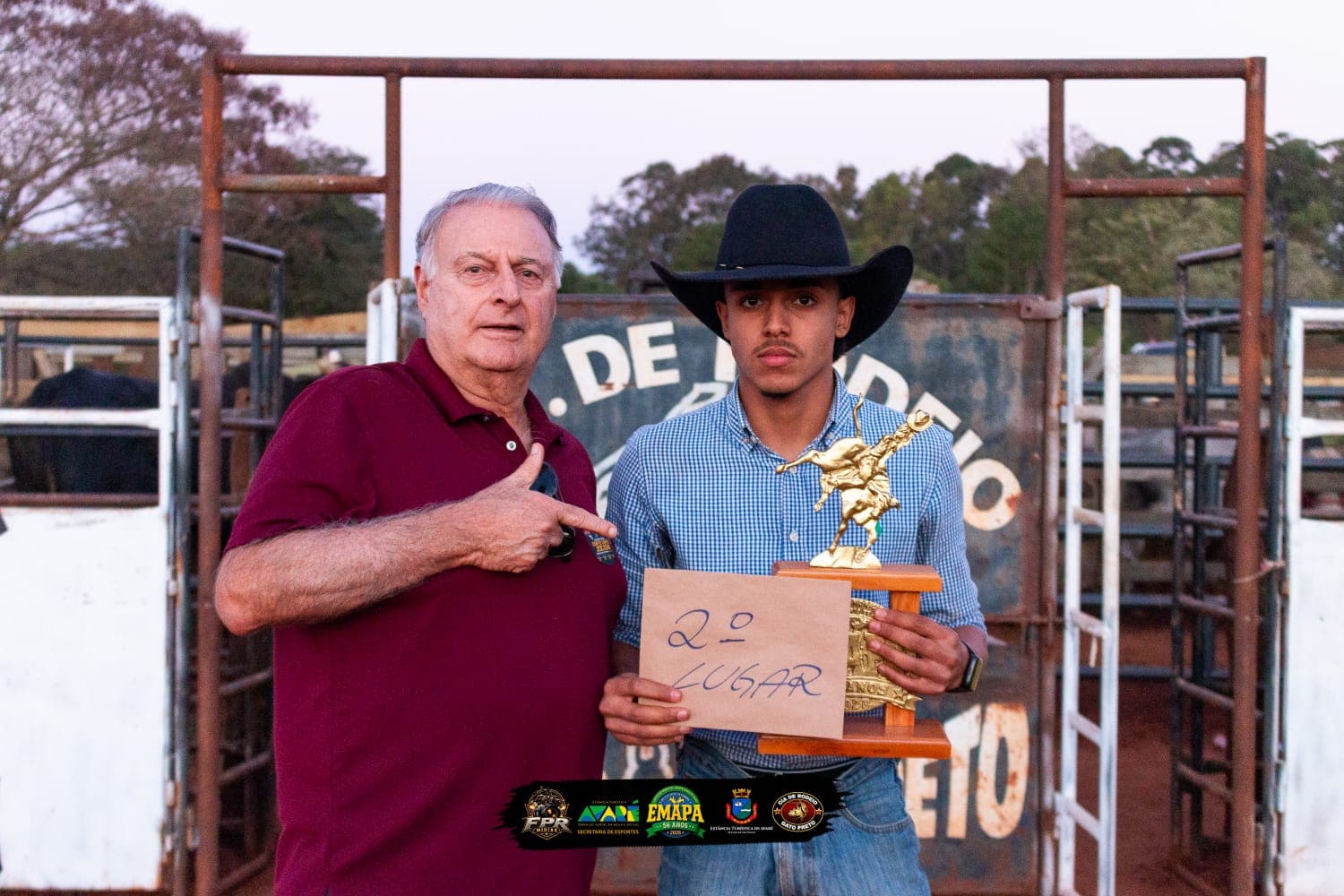 O deputado estadual Capitão Conte Lopes aparece ao lado do peão Mauri Nunes, segundo colocado na seletiva da modalidade cutiano. Mauri usa chapéu preto e segura o troféu e uma placa com a indicação de 2º lugar, enquanto o deputado aponta para o competidor. Ao fundo, aparecem estruturas da arena de rodeio no bairro rural da Ponte Alta, em Avaré.