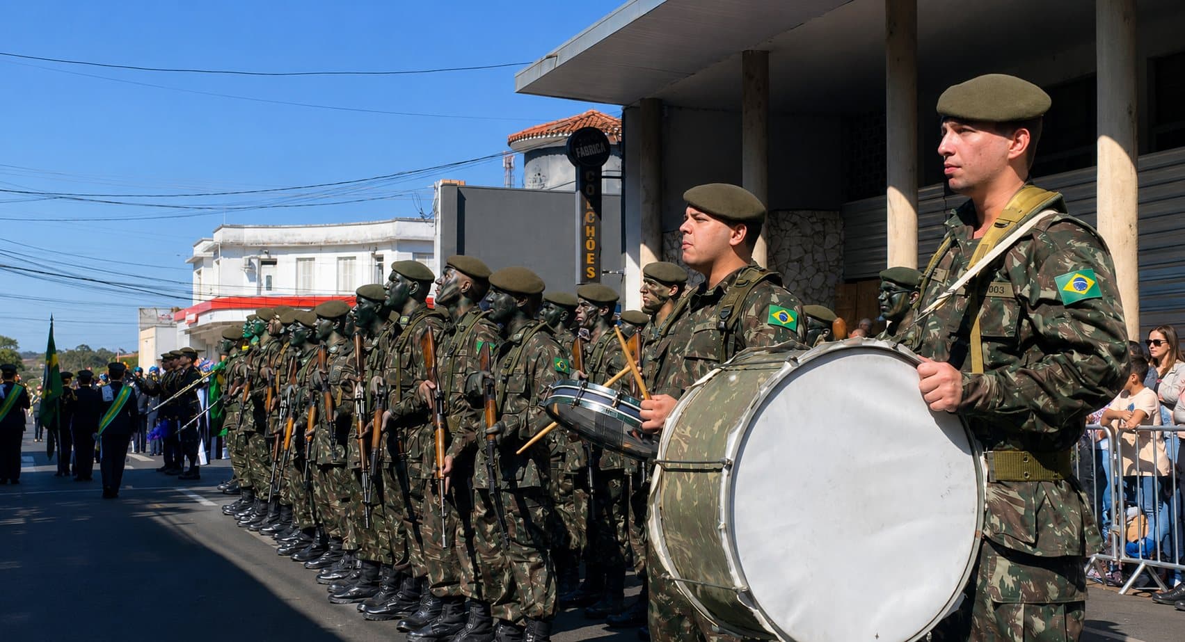 imagem de um Desfile Cívico de aniversário de Avaré, com participantes seguindo pelas ruas centrais enquanto moradores acompanham a celebração nas calçadas.